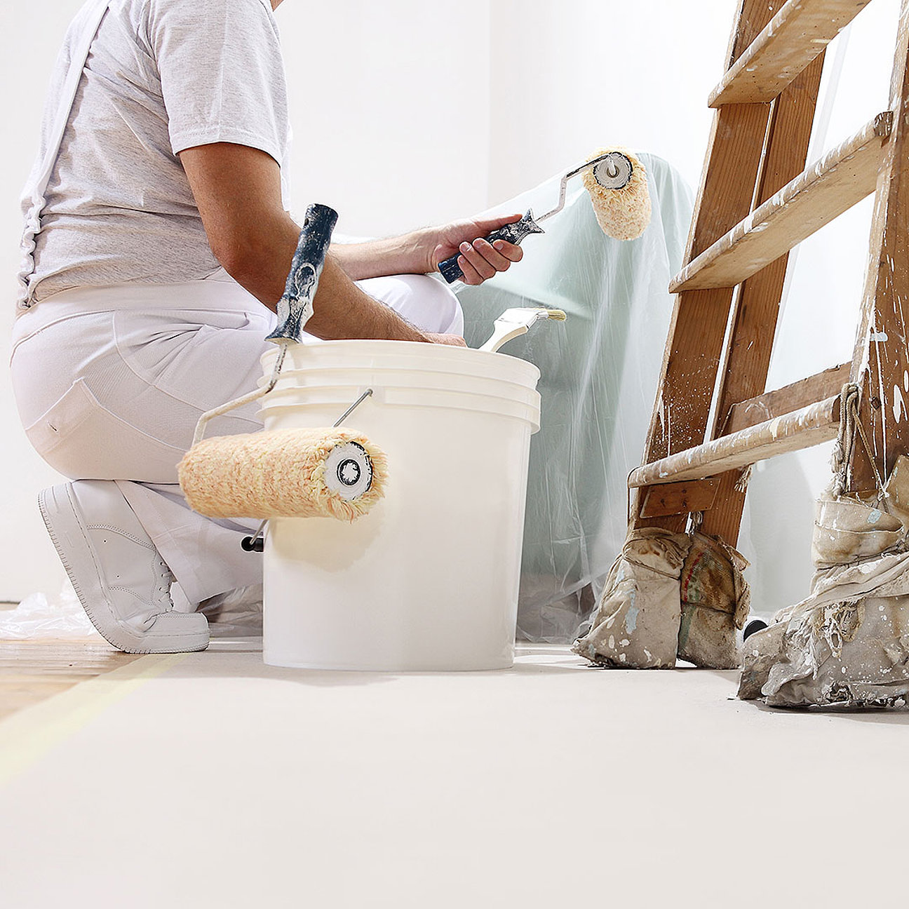 Malerarbeiten an einer Wand in einem renovierten Zimmer