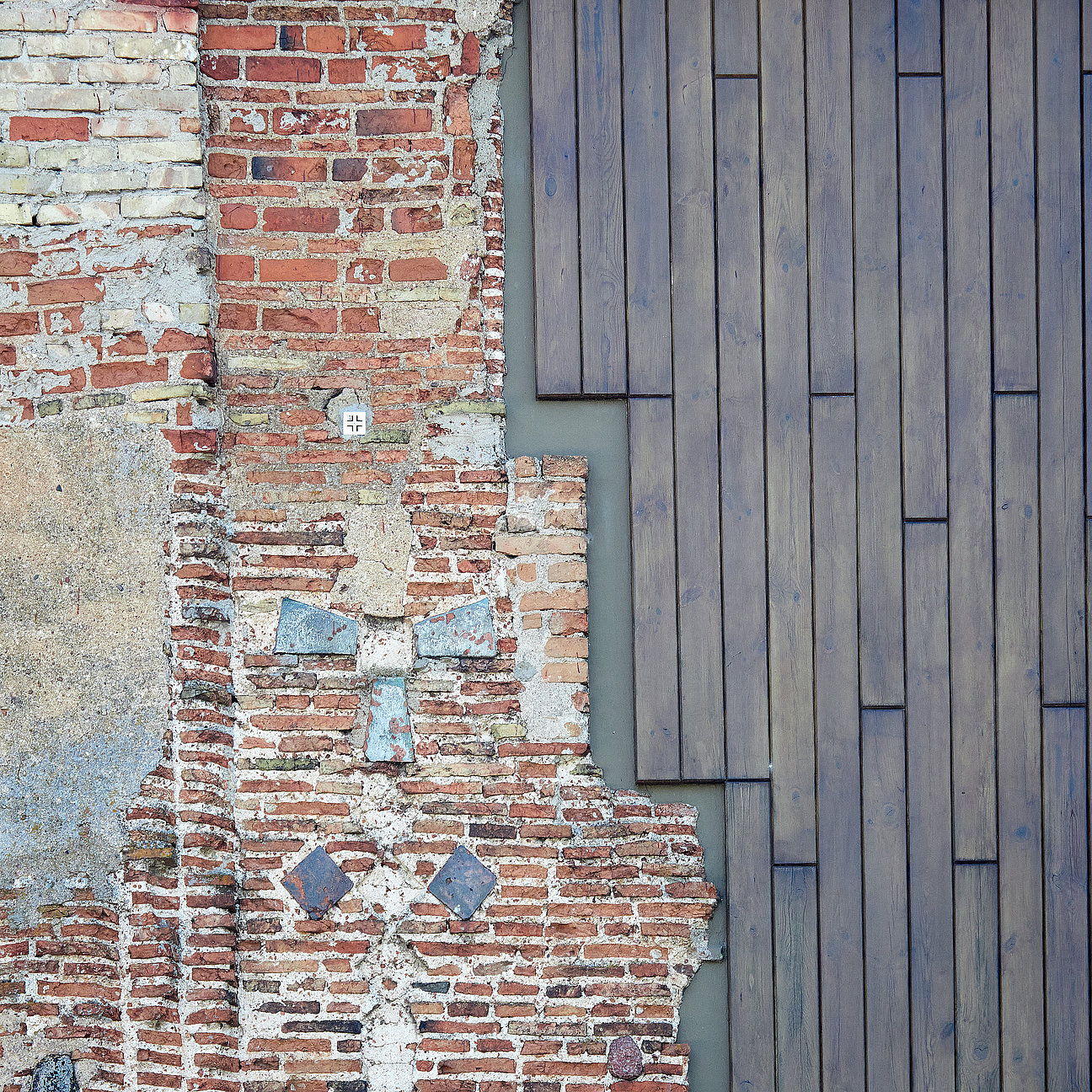 Contrast of old and new. Fragment of the wall of the old building and the new wooden facade Renovierung eines Gründerzeithauses - neue Farbe, bewahrter Charakter
